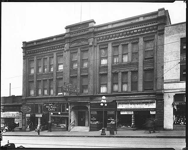 The Hotel New Vendome facade around 1926 with Del Monte Cafe and shop awnings at street level, before the northern half was demolished