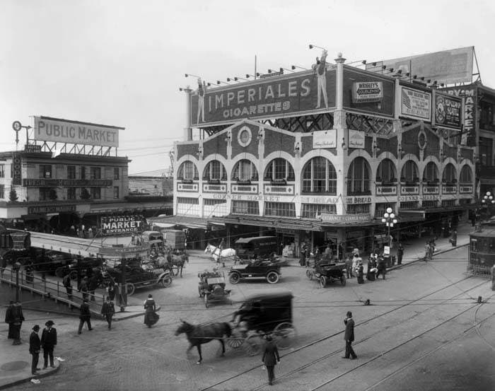 Corner Market Building at 1st and Pike with horse carts, circa 1915