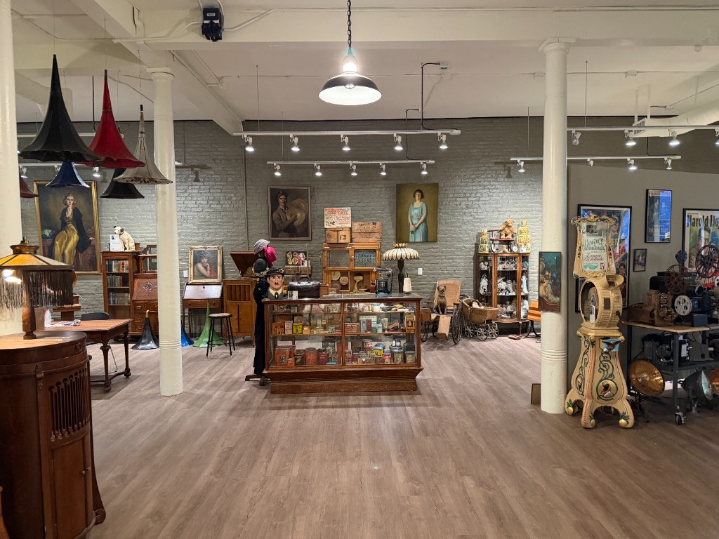 The main exhibition room with paintings, display cases, and film projectors